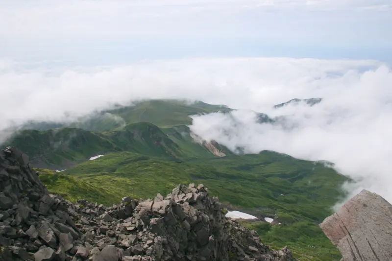 雲の間から見える長い裾野を持つ鳥海山の山ろく