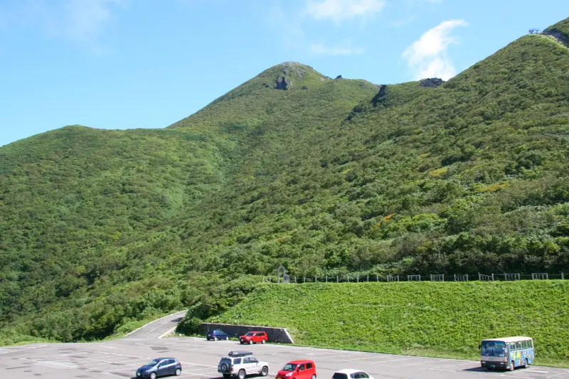 駐車場の奥に見える小高い場所が岩木山の山頂
