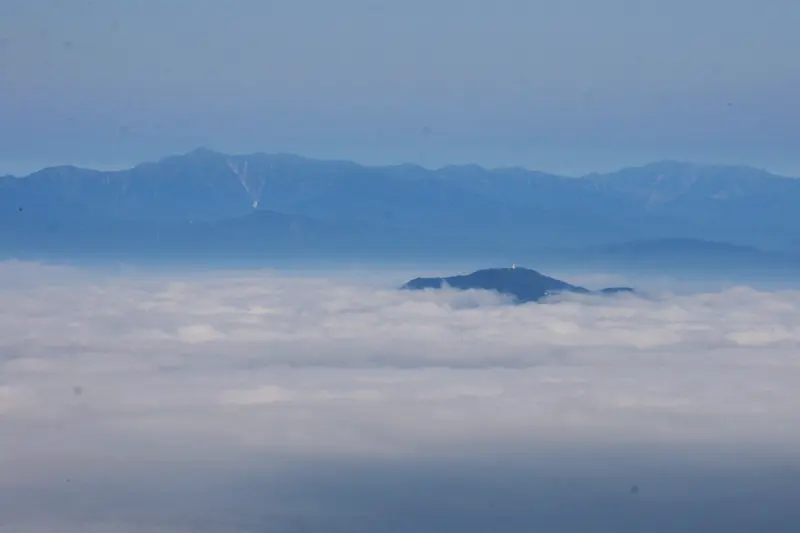 雲海から顔をのぞかせる白鷹山。後ろの山は朝日岳