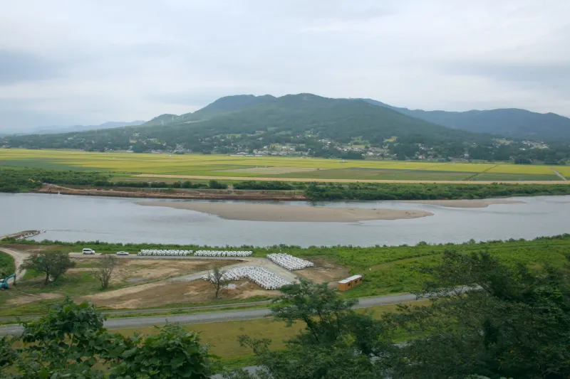 高台から目の前に眺められる北上川と束稲山