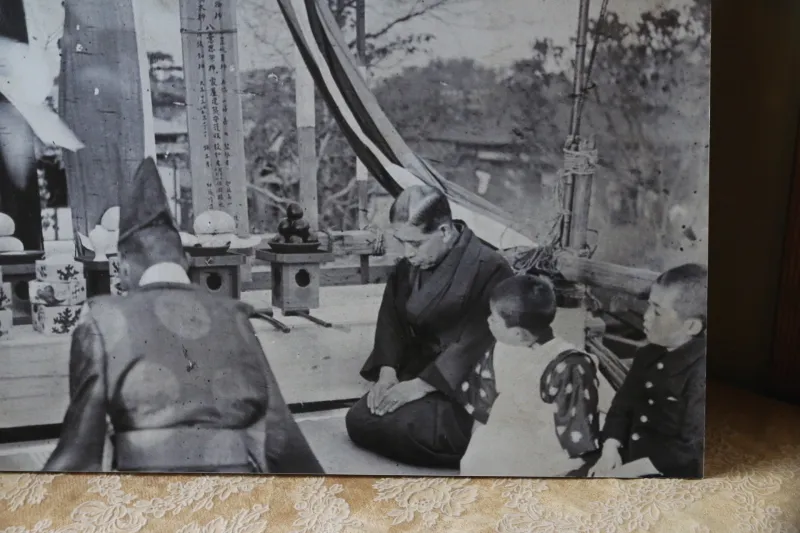 部屋に飾られていた写真に写る上棟式の山崎嘉七氏（写真中央）