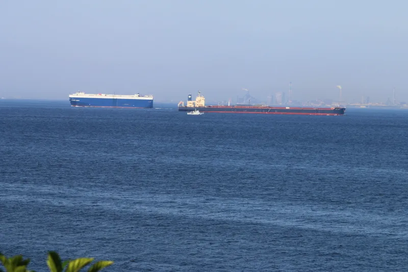 沖合を通過する自動車運搬船とバラ積み貨物船