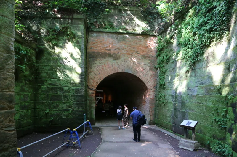 入口が高い壁に覆われているレンガ造りのトンネル
