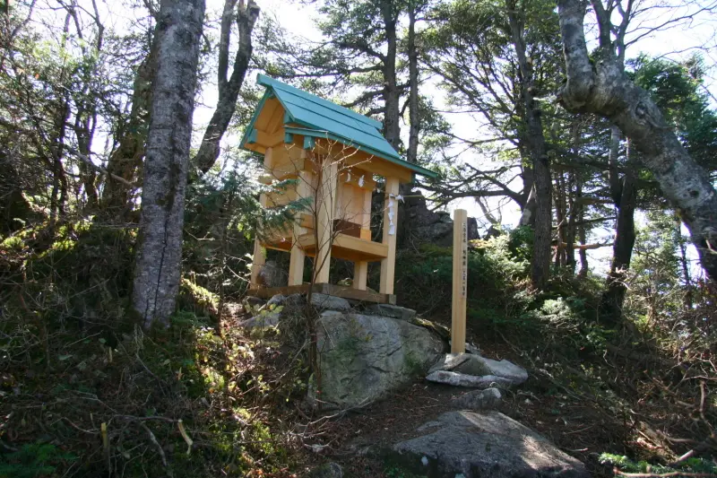 登山道の脇に小さな祠の立つ神明社を通過