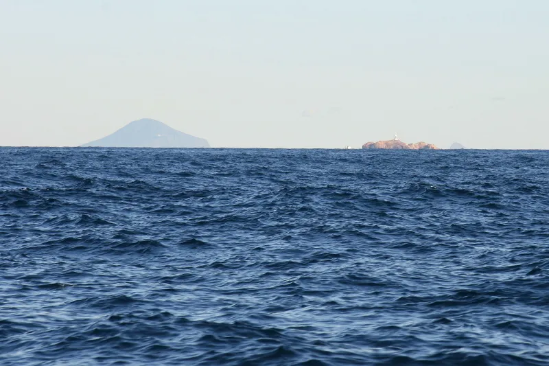 水平線に小さく見える伊豆七島の利島(左)と神子元島(右)