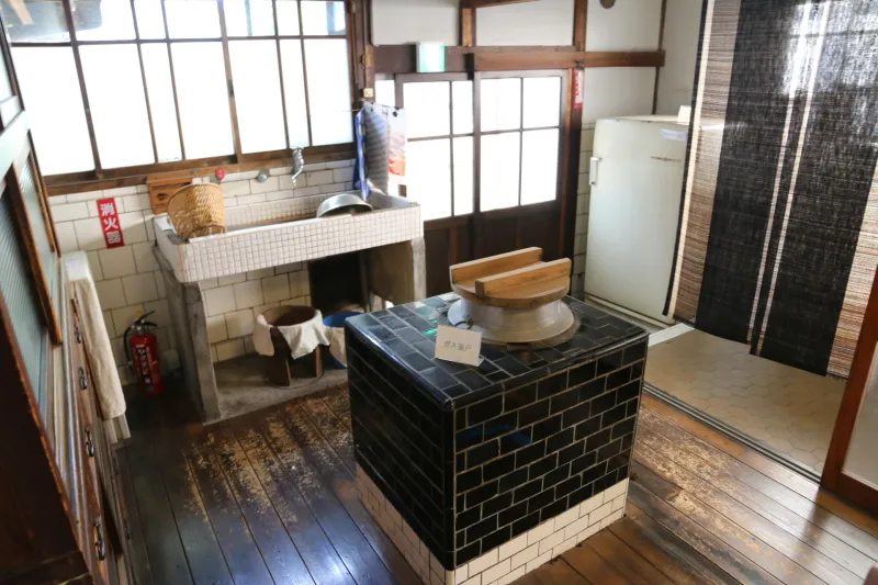 米ＧＥ製の古い冷蔵庫が置かれガス釜戸のある台所