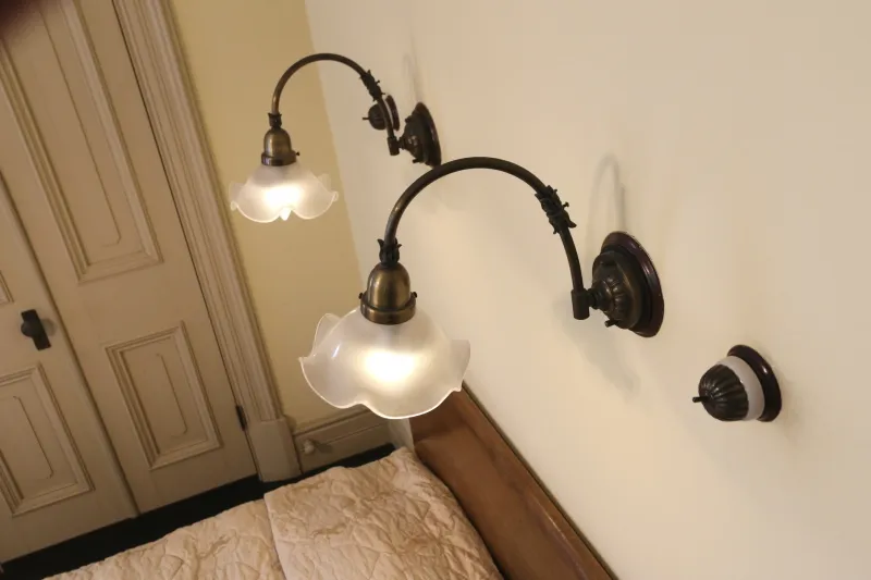 ベッドを照らすように寝室の壁に設置されている照明