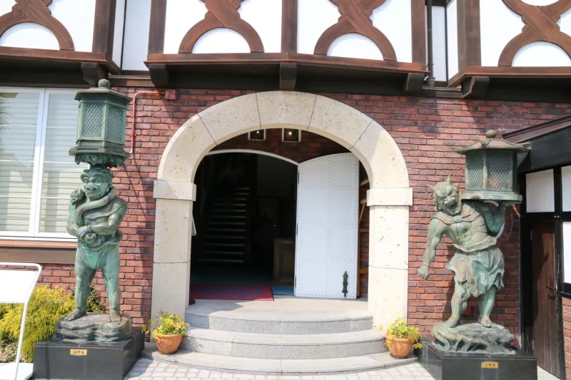 ２体の鬼像が立っている玄関前の光景
