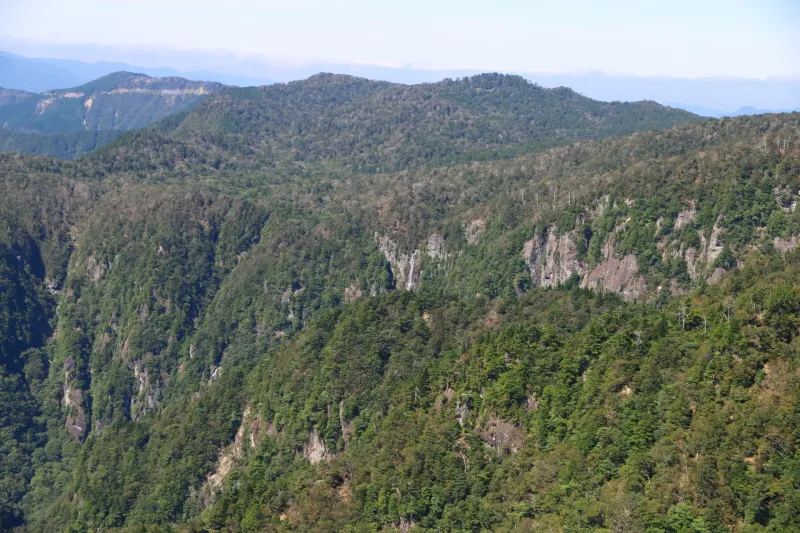 北西方向の山の中に小さく見える中の滝（写真の中央） 