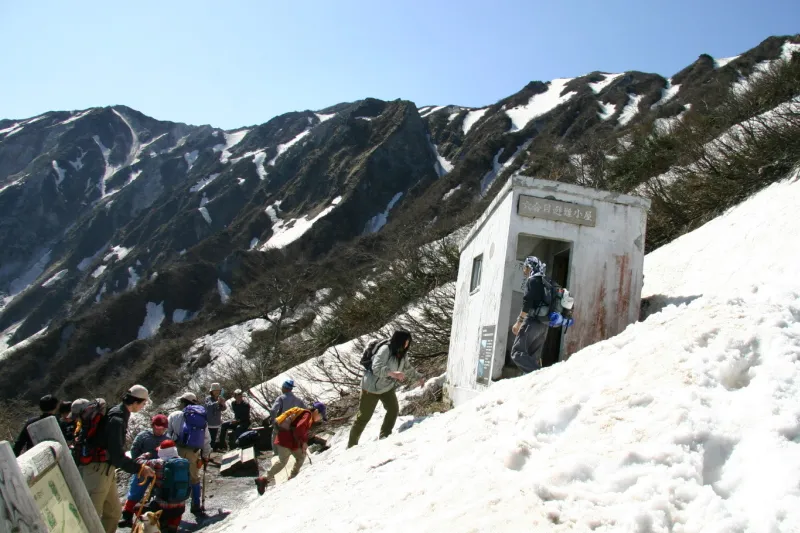 雪で埋もれる避難小屋を見ながら六合目を通過 