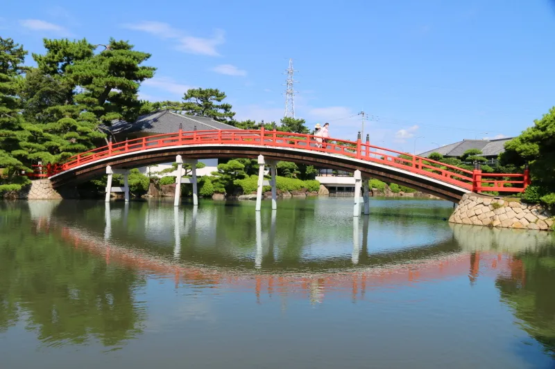 大きな池の中に架けられている朱色の美しい邀月橋 
