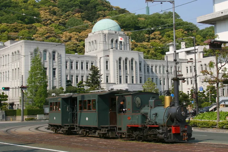 ドームのある洋風建築が特徴となっている愛媛県庁の前を走る光景 