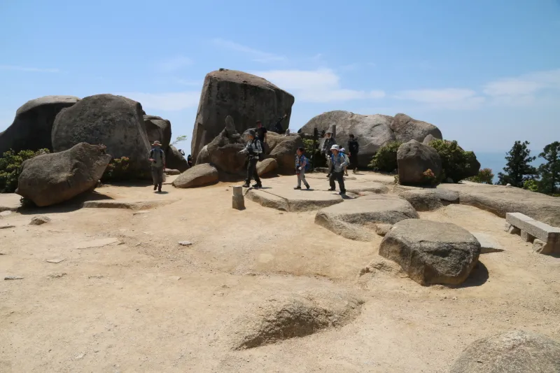広く平らな場所に大岩が見られる山頂スペース 