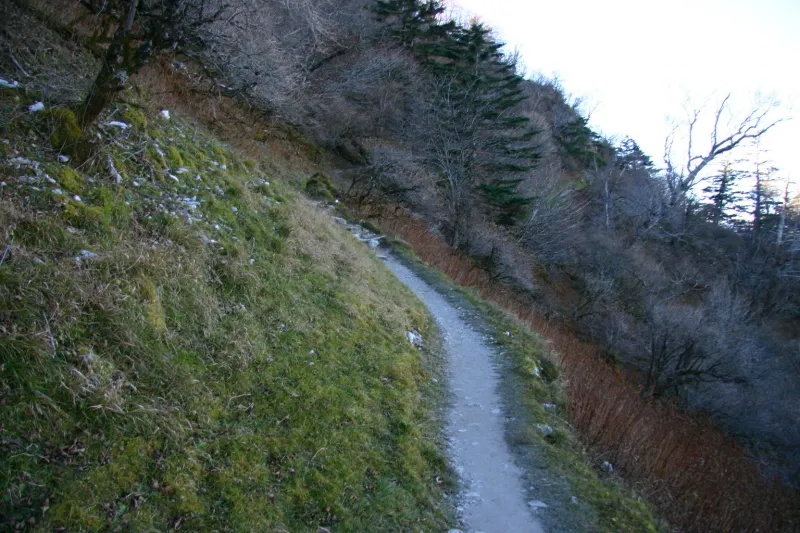 山の斜面に沿って細い道が続く登山道 
