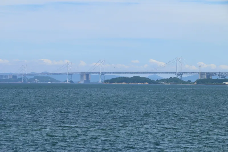 遠くに小さく見える本州と四国をつなぐ瀬戸大橋 