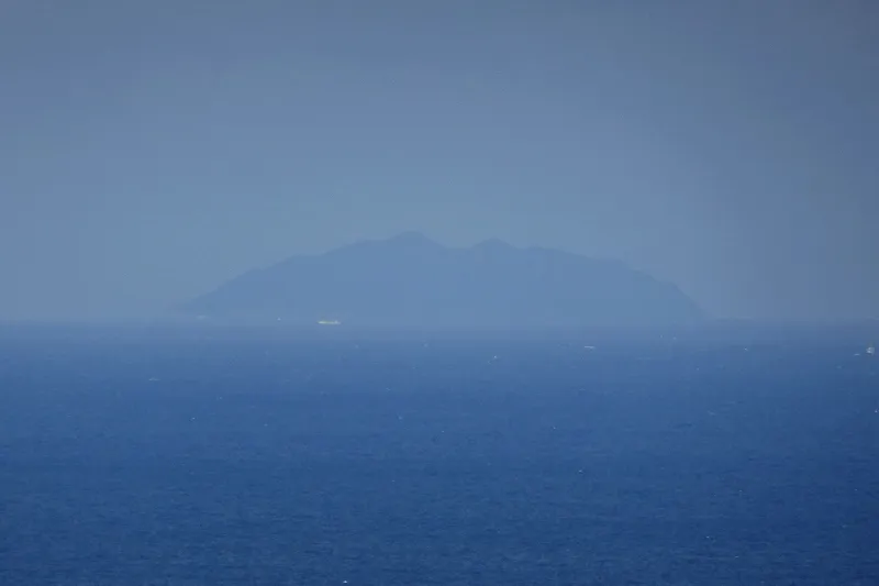 望遠レンズで撮影すると見える沖ノ島の島影 