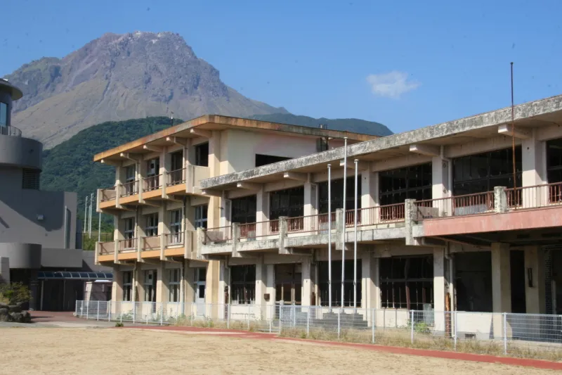 建物の後ろに平成新山の見える旧大野木場小学校被災校舎 