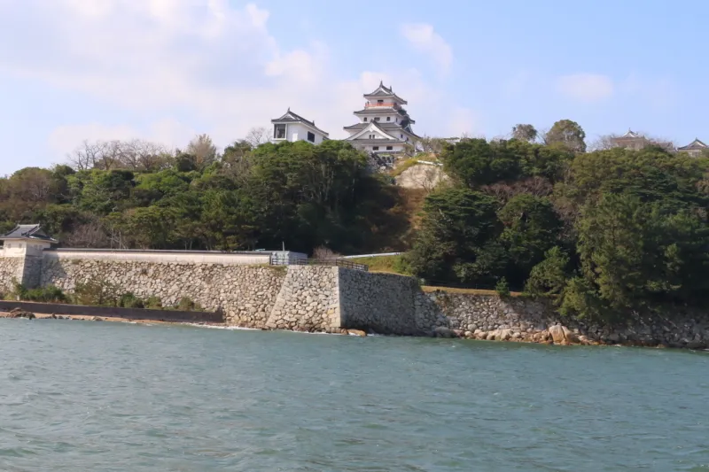 海上から眺める唐津城の天守閣と石垣 